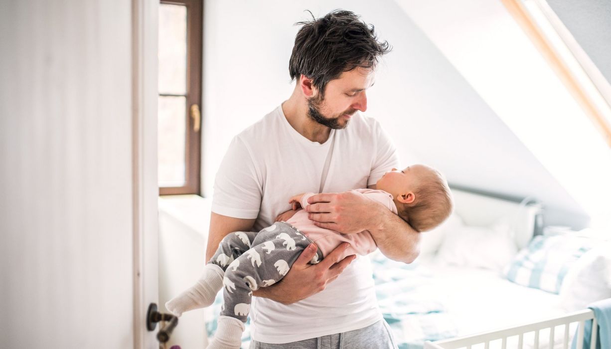 Vater, hält sein Baby im Arm.