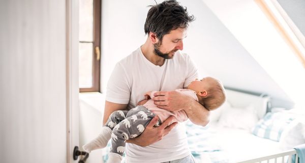 Vater, hält sein Baby im Arm.