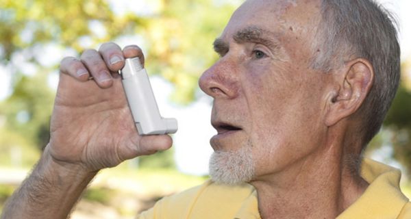 Älterer Mann nutzt Asthma-Spray.