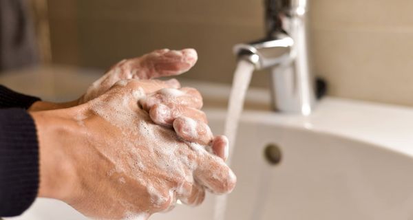 Mann, wäscht seine Hände mit Seife.