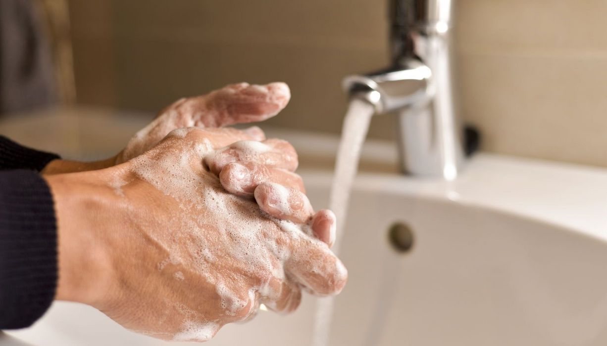 Mann, wäscht seine Hände mit Seife.