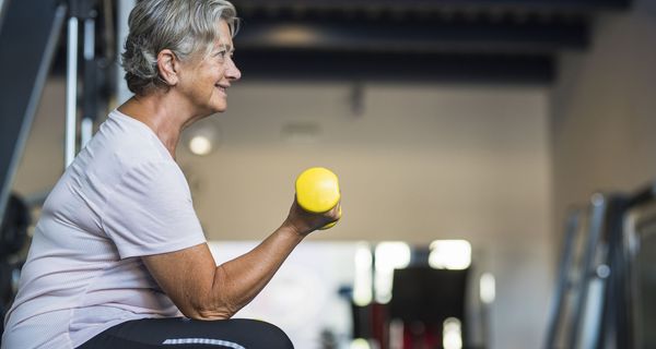 Ältere Frau, macht Kraftsport mit einer kleinen Hantel.