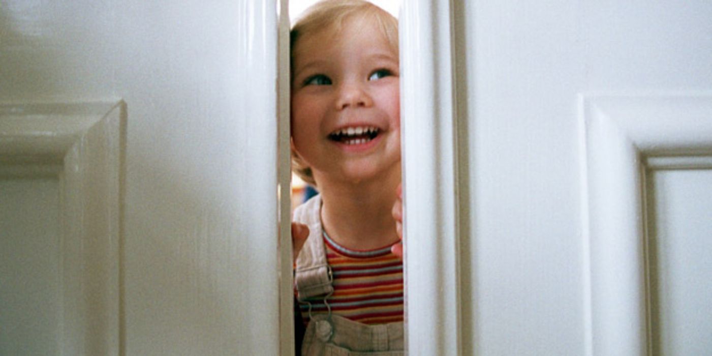 Kleines Mädchen lugt durch einen Türspalt