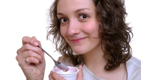 Junge Frau isst Joghurt