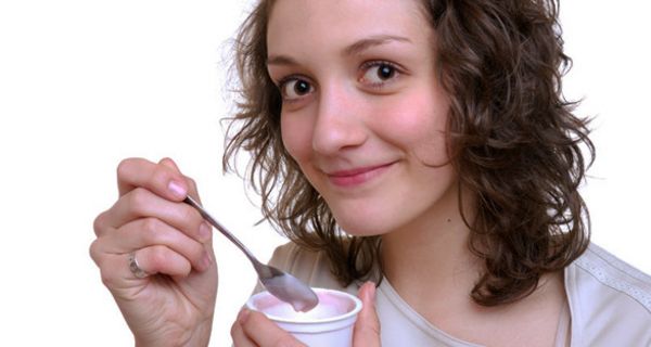 Junge Frau isst Joghurt