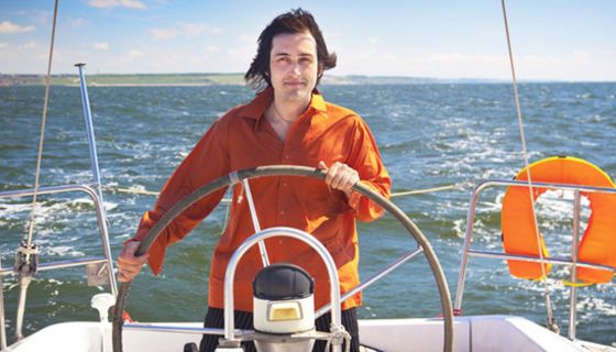 Mann am Steuer eines Segelbootes