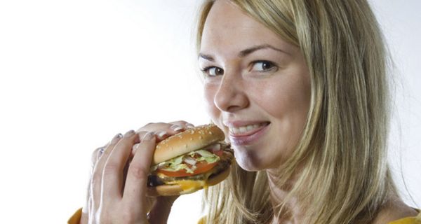 Frau beißt in Hamburger.