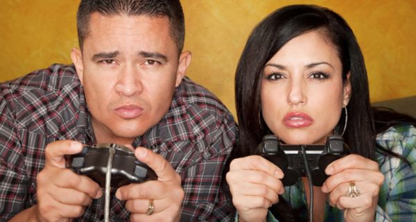 Junge Frau und junger Mann mit Videospiel-Konsolen