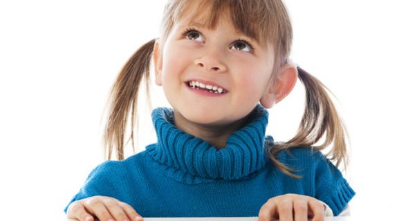 Mädchen mit blauem Pullover und schönen Zähnen schaut nach oben