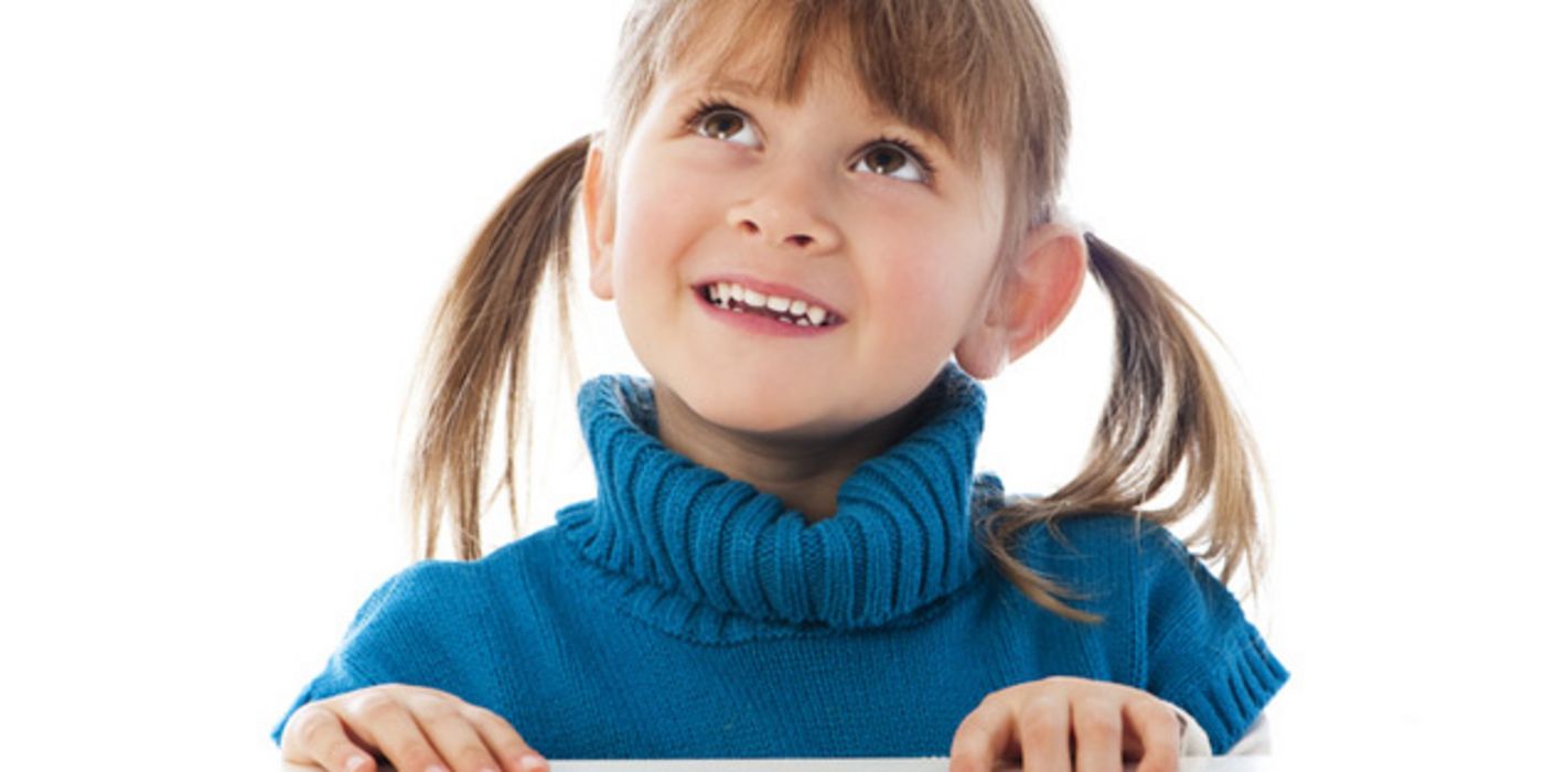 Mädchen mit blauem Pullover und schönen Zähnen schaut nach oben