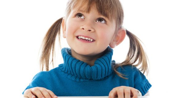 Mädchen mit blauem Pullover und schönen Zähnen schaut nach oben