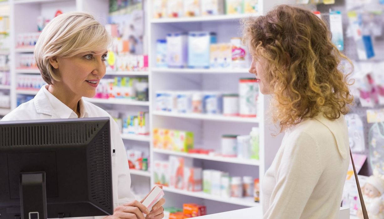 Junge Dame wird von Apothekerin beraten