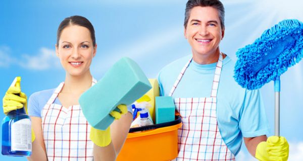 Frau und Mann mit Schürzen, Putzmitteln und Schwämmen startklar zur Hausarbeit