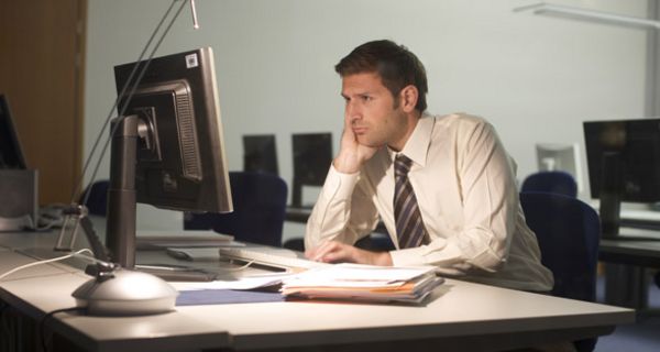 Mann sitzt im Büro vor dem Computer.