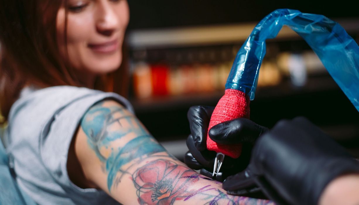 Frau bekommt ein farbiges Tattoo