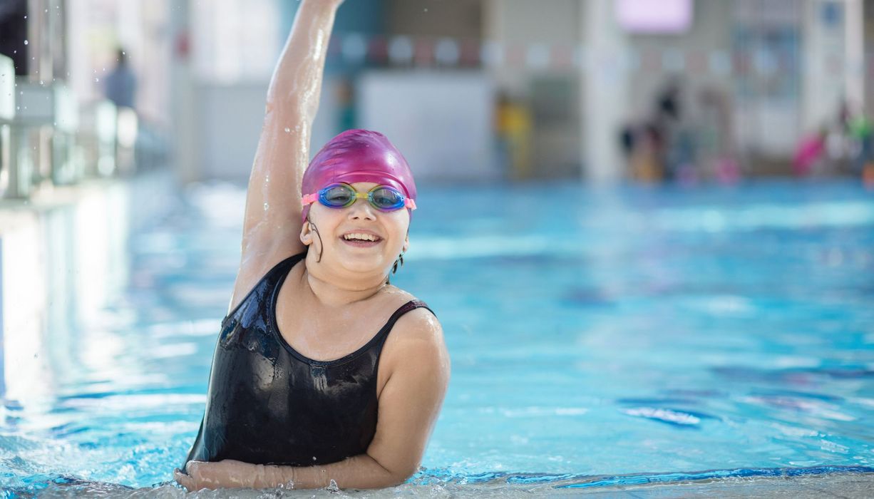 Junges Mädchen mit Übergewicht im Schwimmbad.