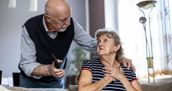 Senior, kümmert sich um seine Frau mit Brustschmerzen.