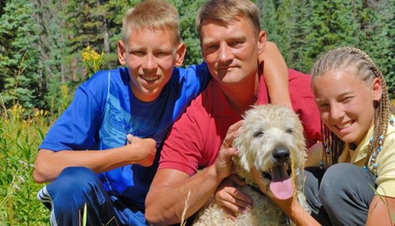 Vater mit Tochter und Sohn im Teenager-Alter und Hund in der Natur