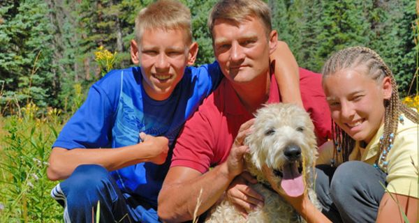 Vater mit Tochter und Sohn im Teenager-Alter und Hund in der Natur
