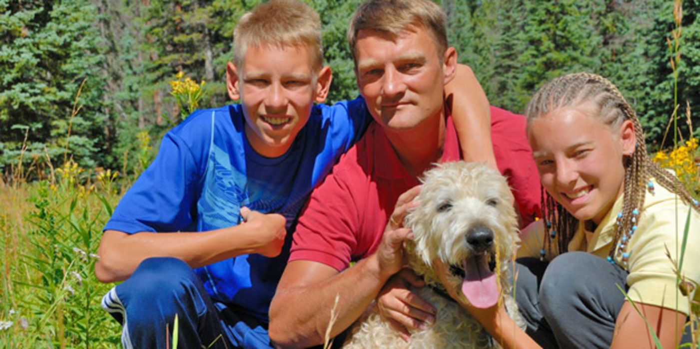 Vater mit Tochter und Sohn im Teenager-Alter und Hund in der Natur