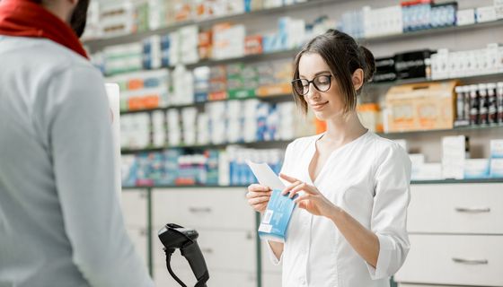 Junge Apothekerin, scannt ein Medikament ab.