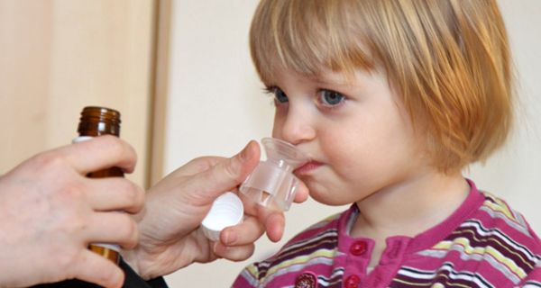 Kind bekommt Antibiotikum-Saft verabreicht