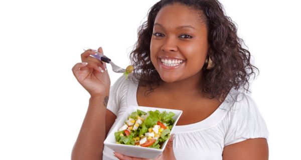 Füllige Frau isst einen Salat