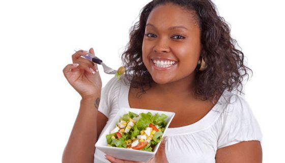 Füllige Frau isst einen Salat