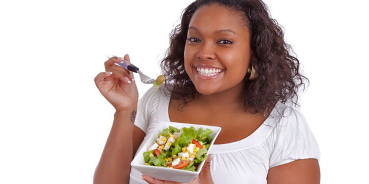 Füllige Frau isst einen Salat