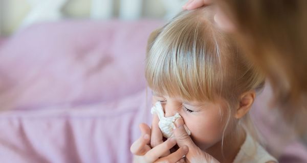 Mutter, hilft kleinem Mädchen dabei, die Nase zu putzen.