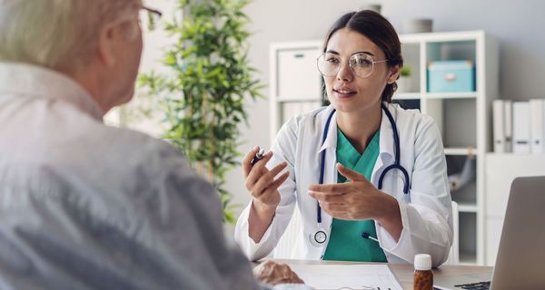 Junge Ärztin, spricht mit Patienten.