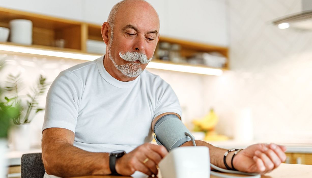 Älterer Herr misst seinen Blutdruck.