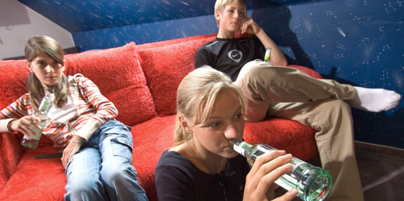 Jugendliche trinken Alkohol und sehen dabei fern