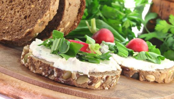Zwei runde Scheiben Vollkornbrot mit Quark-Aufstrich