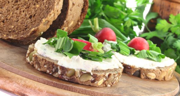 Zwei runde Scheiben Vollkornbrot mit Quark-Aufstrich