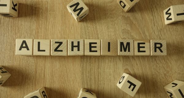 Holzklötze mit Buchstaben sind so aneinandergereiht, dass sie das Wort Alzheimer ergeben.