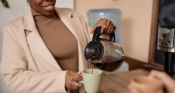 Frau, gießt sich Kaffee ein.