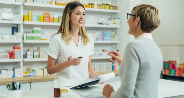 Junge Apothekerin berät Kundin.