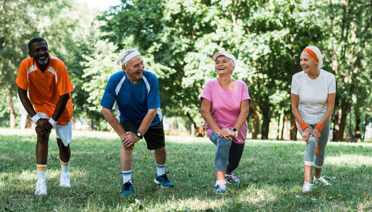 Ältere Menschen, treiben zusammen Sport im Park.