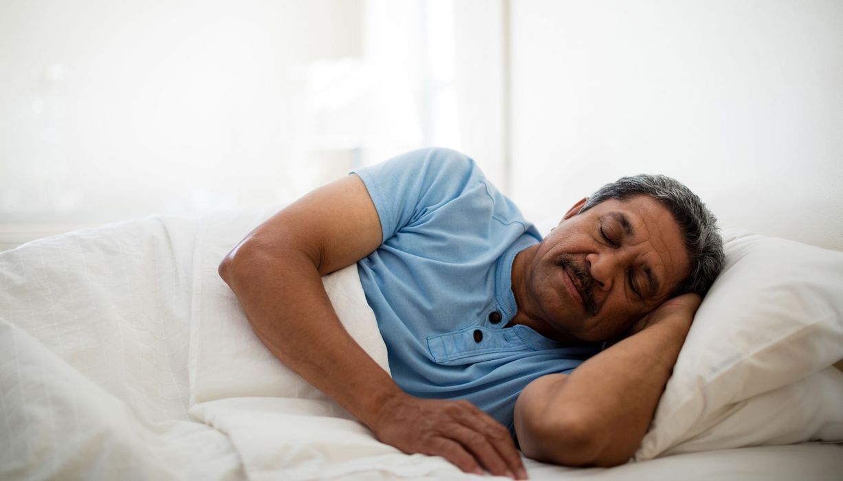 Mann, liegt im Bett schläft. 