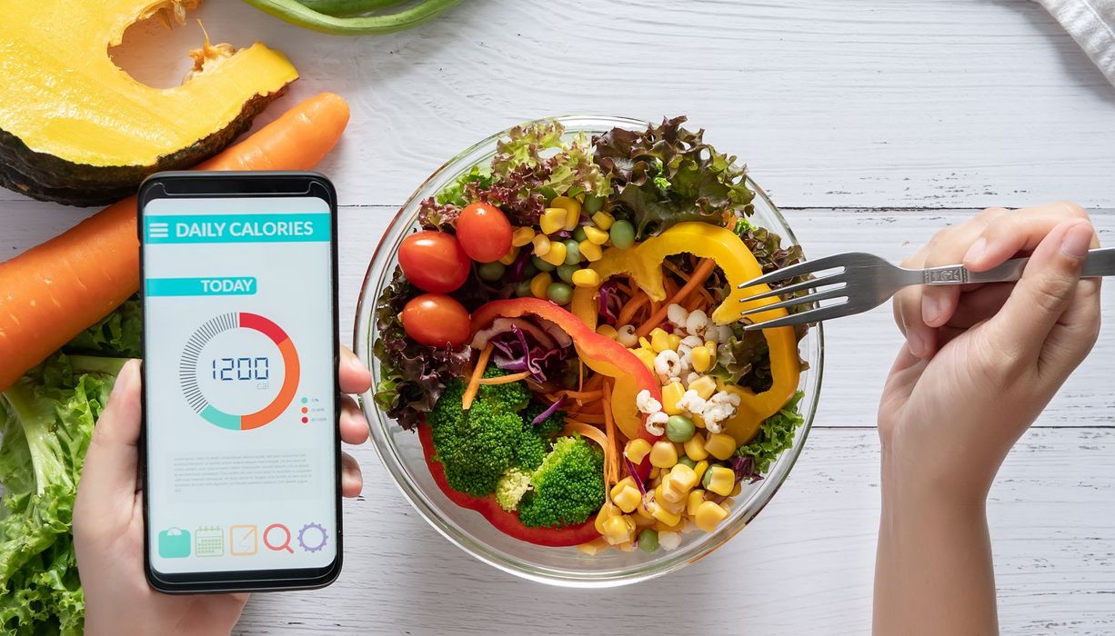 Salat mit Smartphone und Diät-App.