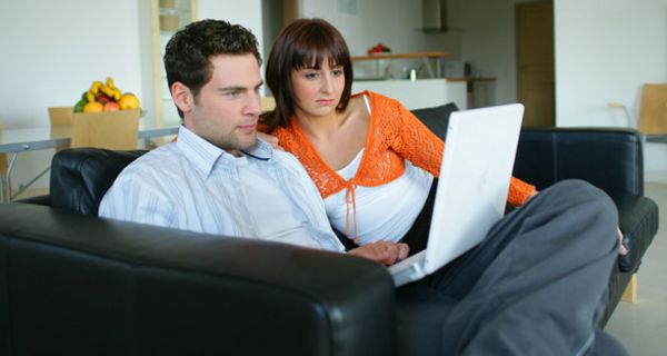 Mann un Frau sitzen vor einem Laptop.