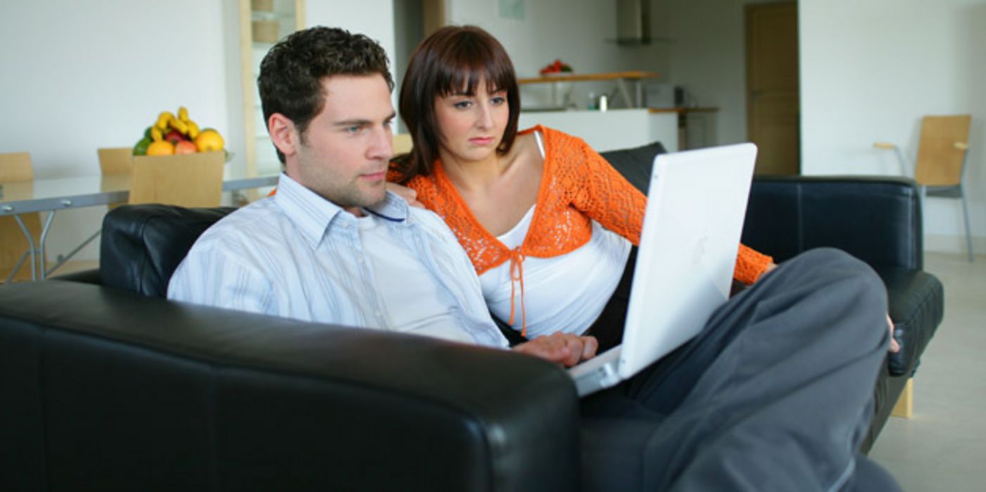 Mann un Frau sitzen vor einem Laptop.