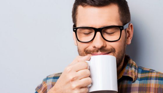 Junger Mann trinkt eine Tasse Kaffee.