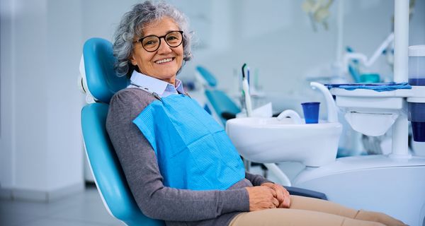 Seniorin auf einem Zahnarztstuhl.
