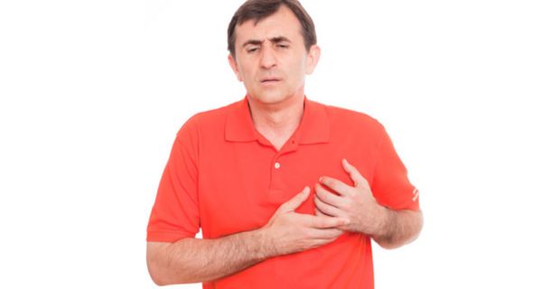 Mann in mittlerem Alter mit rotem Hemd fasst sich voller Sorgen ans Herz