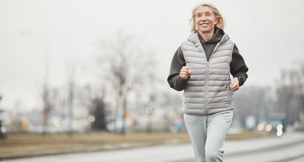 Ältere Frau, joggt an einem winterlichen Tag.