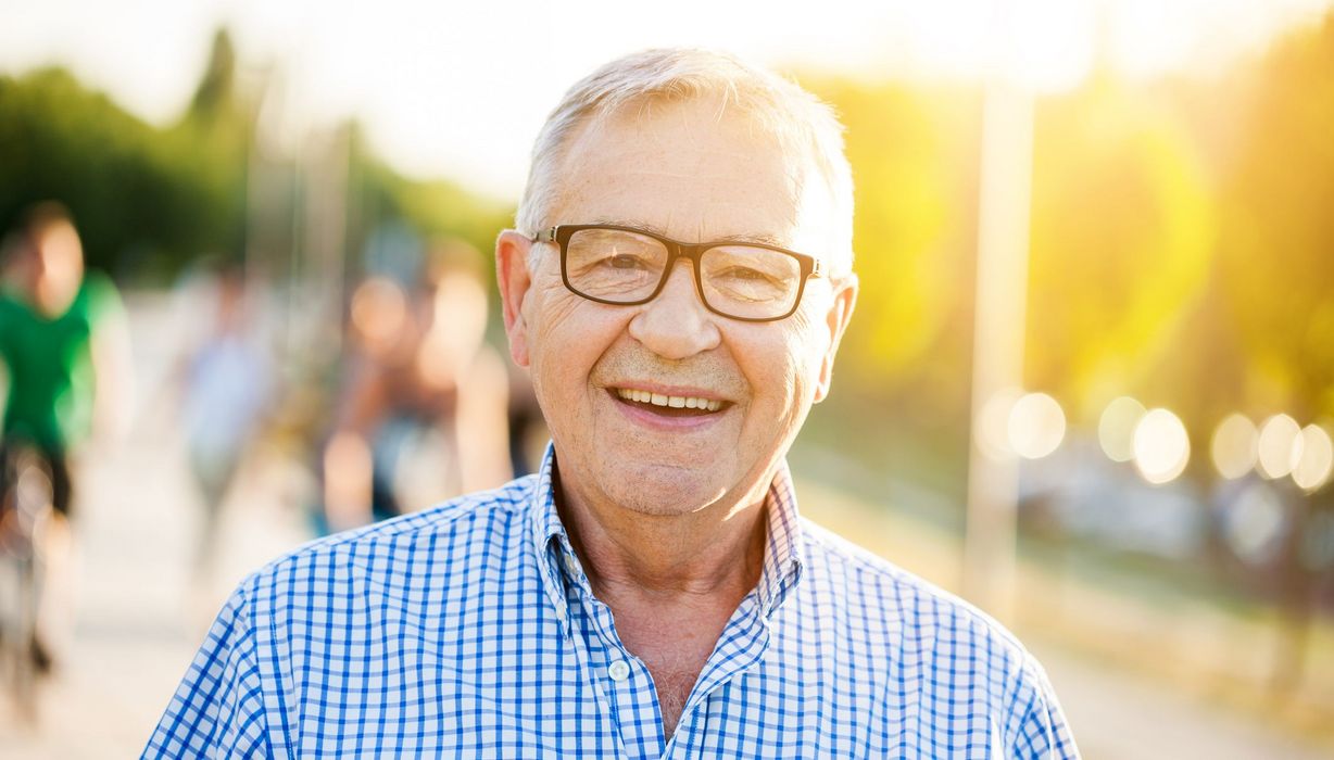 Älterer Mann mit Brille und kariertem Hemd.
