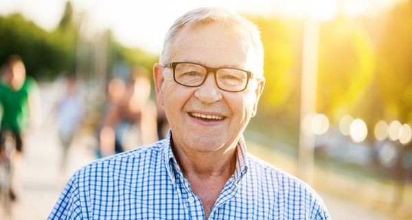 Älterer Mann mit Brille und kariertem Hemd.