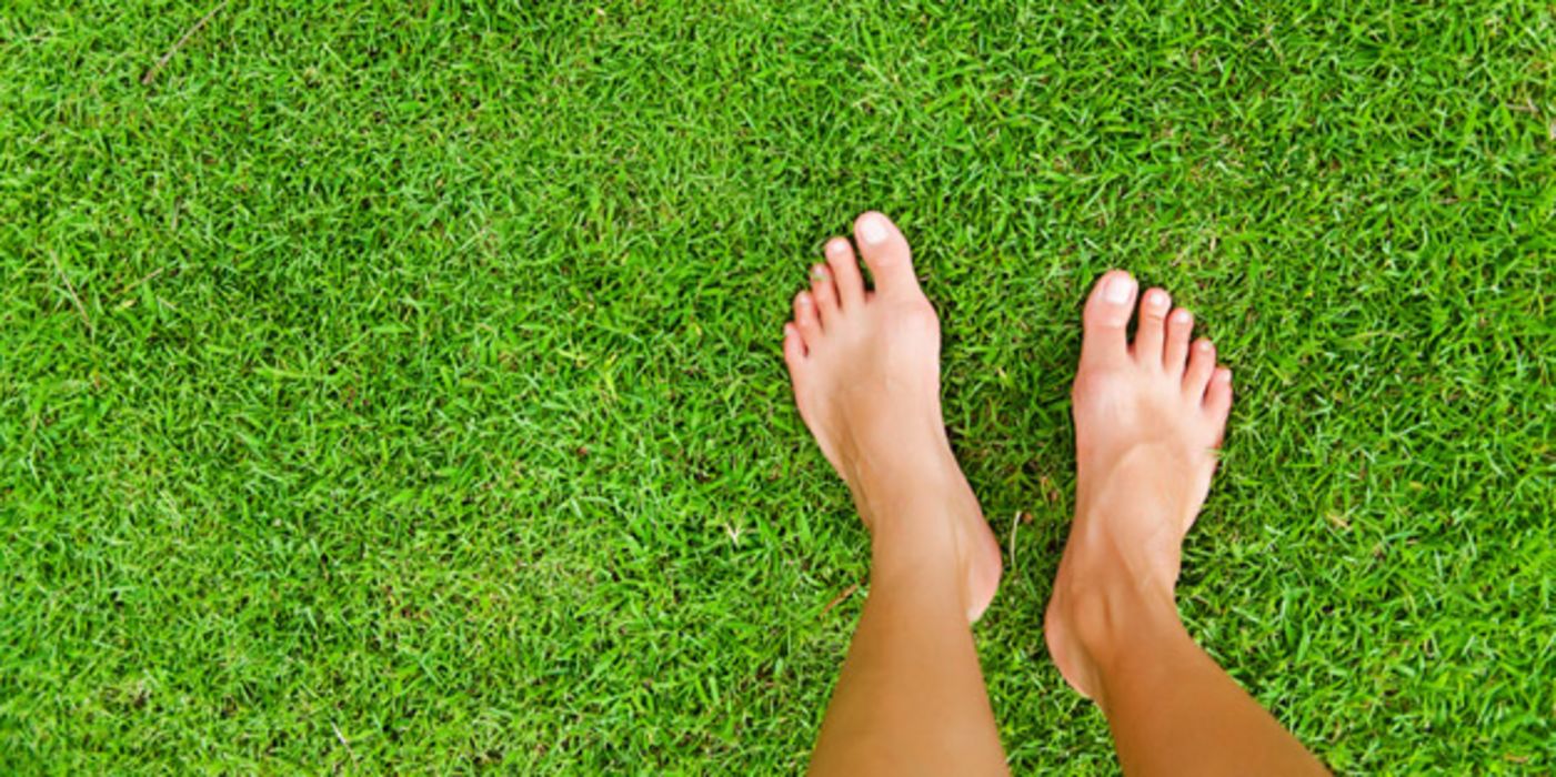 Füße auf grünem Rasen
